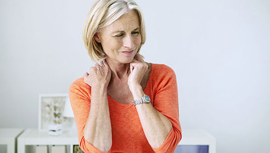 Mature woman suffering from neck and shoulder pain before visiting Denver chiropractor