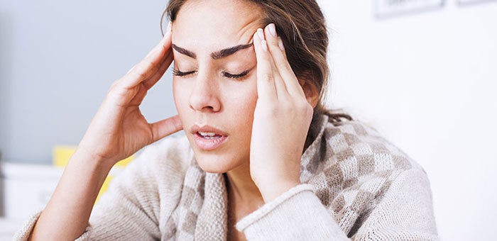 Woman suffering from headache before visiting Denver chiropractor