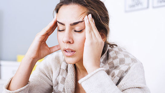 Woman suffering from headache before visiting Denver chiropractor